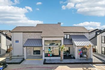 A house with a grey roof and a white wall with a black awning.